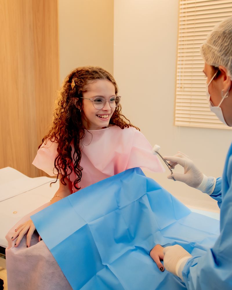 Paciente sorrindo enquanto a enfermeira a prepara para a cirurgia