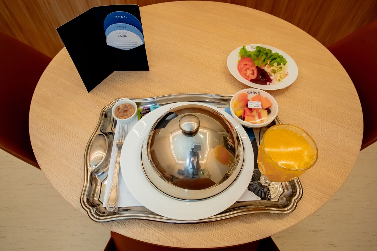 Bandeja de refeição servida no quarto, com prato quente, frutas e suco